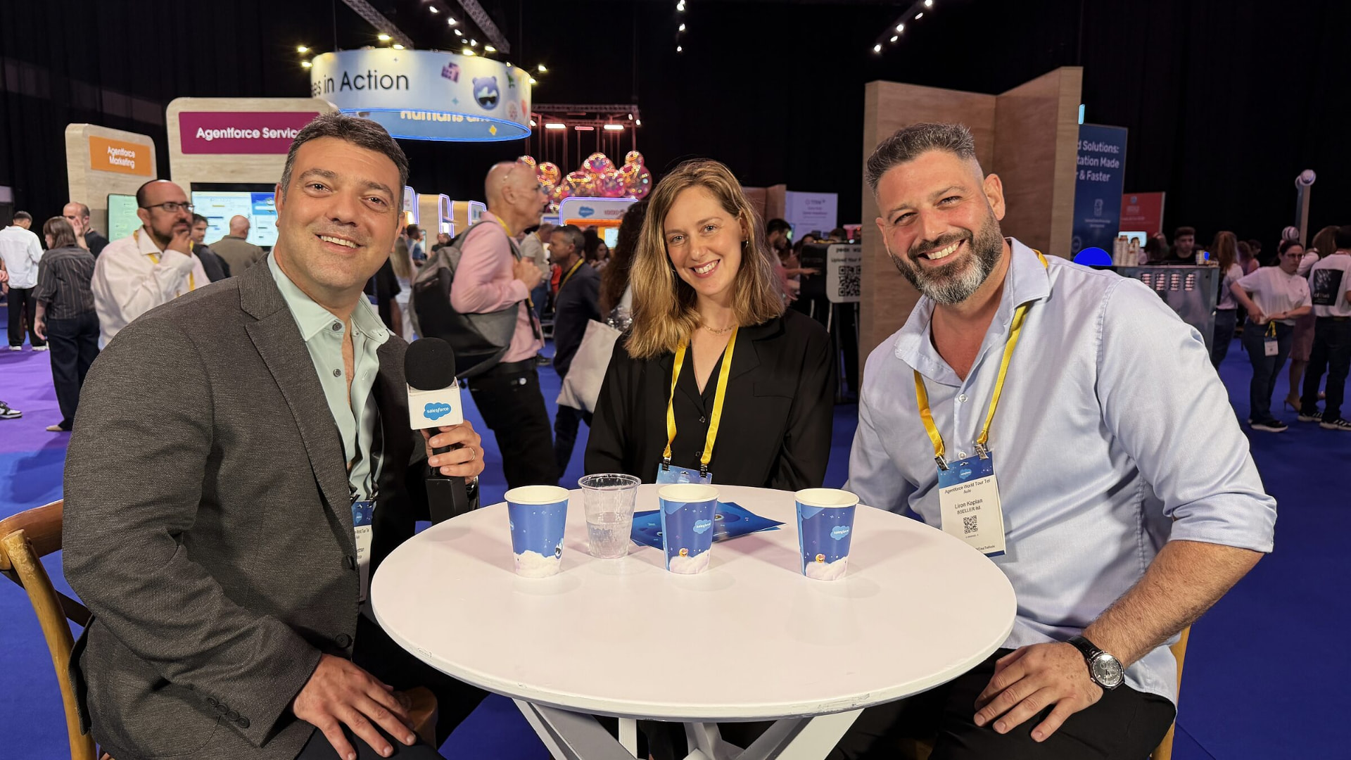 Liron Kaplan being interviewed at a Salesforce conference alongside two other guests